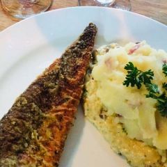 A picture of Hake Fish, Bacon Mashed potatoes on the bed of cheese.