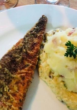 A picture of Hake Fish, Bacon Mashed potatoes on the bed of cheese.