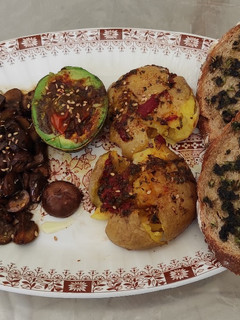 Una foto de Patatas aplastadas, champiñones y aguacate con tostadas