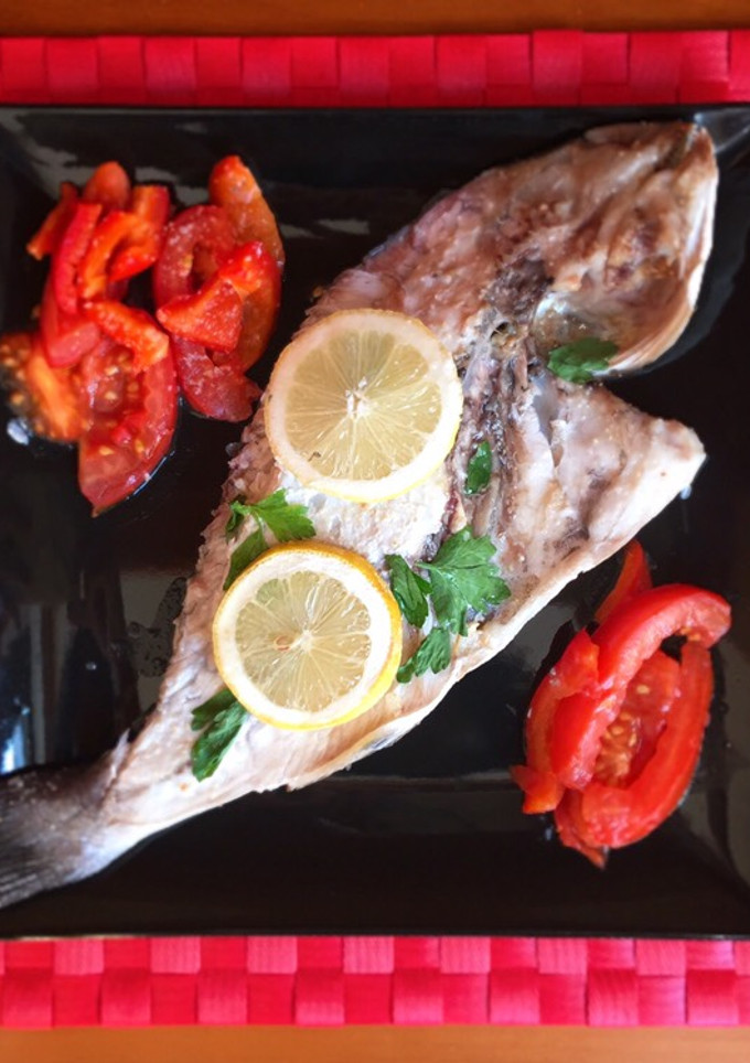 Una foto de Dorada al horno con tomate y pimiento