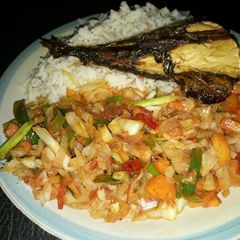 A picture of White rice with vegetable sauce and grilled titus fish.