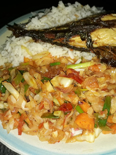 A picture of White rice with vegetable sauce and grilled titus fish.