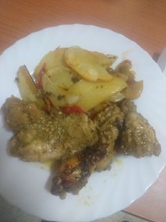 Una foto de Pollo embarrado con papas panaderas