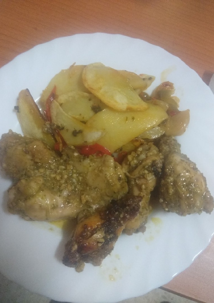 Una foto de Pollo embarrado con papas panaderas