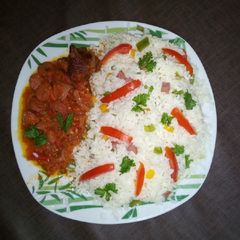 A picture of Veggie rice with hotdog sauce and chicken.