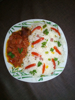 A picture of Veggie rice with hotdog sauce and chicken.