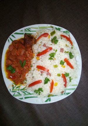 A picture of Veggie rice with hotdog sauce and chicken.