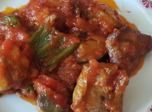 Una foto de Costillejas de cerdo con tomate frito pimientos y berenjenas