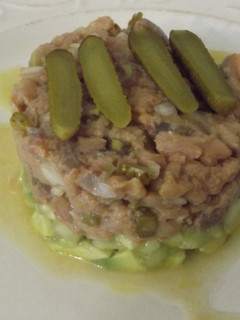 Una foto de Timbal de bonito y aguacate con cebolleta y pepinillos
