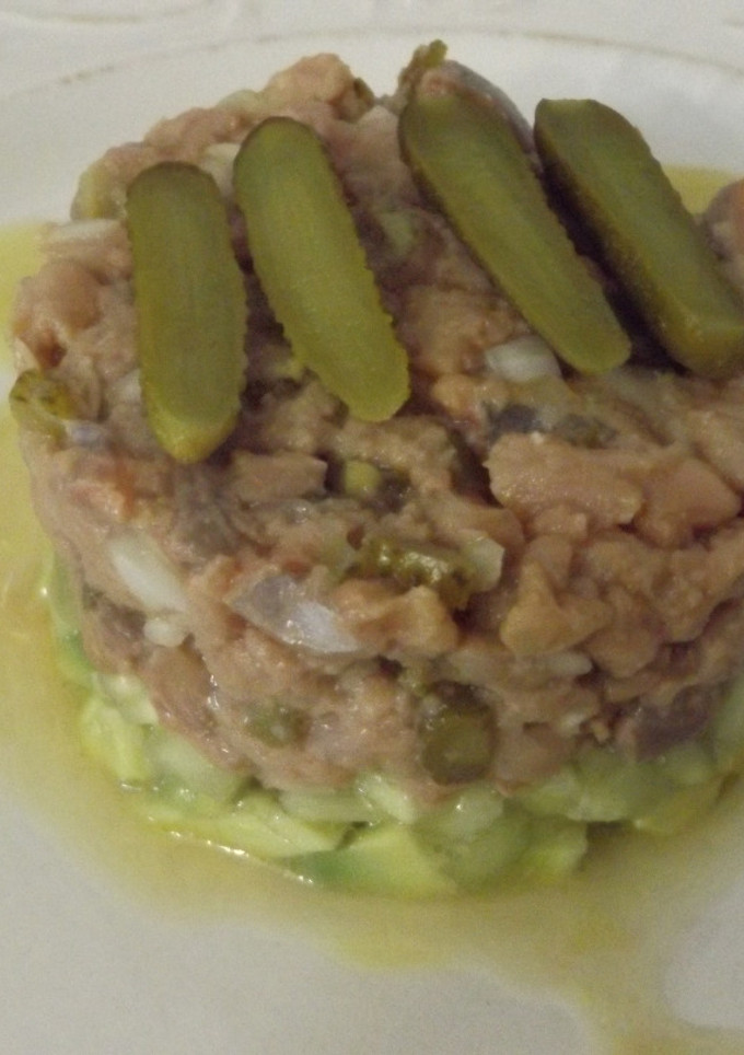 Una foto de Timbal de bonito y aguacate con cebolleta y pepinillos