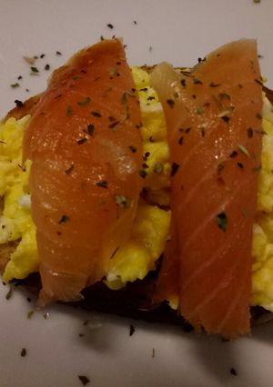 A picture of Smoked salmon and scrambled egg on toasted oregano bread.