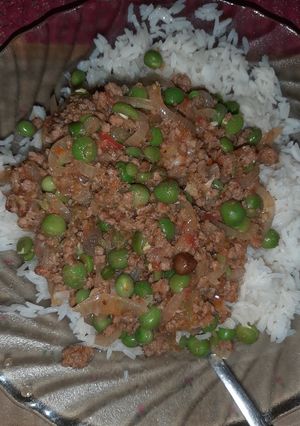 A picture of Minced meat and green peas stew served with rice.