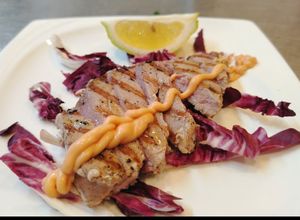 Foto di Tagliata di Tonno Fresco Arrostito con Salsa Cocktail su Letto di Radicchio