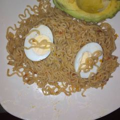 A picture of Cooked Indomie and Boiled eggs with Avocado.