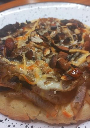 Una foto de Pizza de almendras, cebolla y hongos