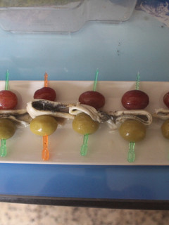 Una foto de Banderillas de boquerones, uvas negras y aceitunas