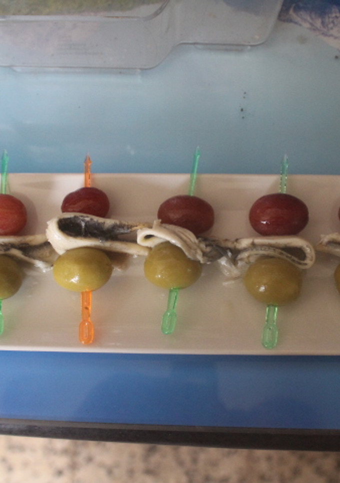Una foto de Banderillas de boquerones, uvas negras y aceitunas