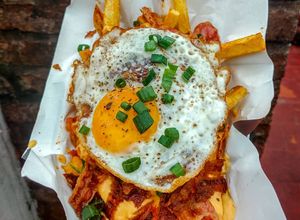 Una foto de Papas fritas triple cocción con cheddar y panceta