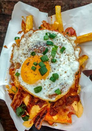 Una foto de Papas fritas triple cocción con cheddar y panceta