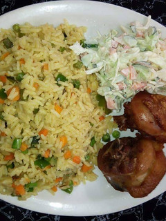 A picture of Fried rice with chicken and coleslaw.