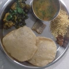 A picture of Puri,gobi matar,barfi and aloo tamatar ki sabji.