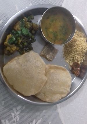 A picture of Puri,gobi matar,barfi and aloo tamatar ki sabji.