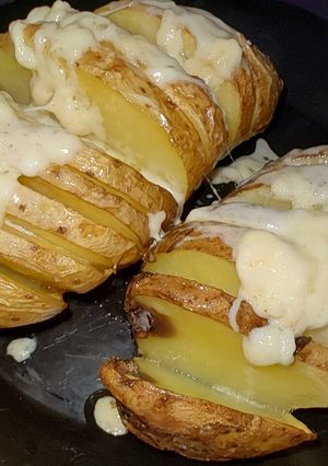 Una foto de Papas al horno con cáscara y queso fundido