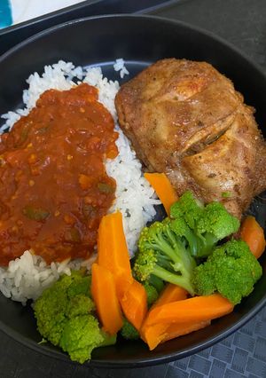 A picture of Grilled Chicken Thighs with Rice, Steamed Veggies & Tomato Gravy.