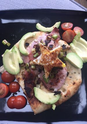 A picture of Flatbread, bacon, egg and avocado 🥑.