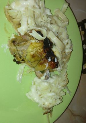 Una foto de Pollo relleno Acompañado con salsa blanca y fideos