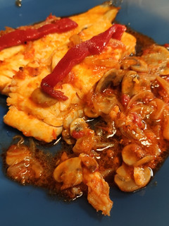 Una foto de Bacalao con cebolla, champis y salsa de tomate y pimientos de piquillo