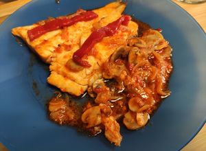 Una foto de Bacalao con cebolla, champis y salsa de tomate y pimientos de piquillo