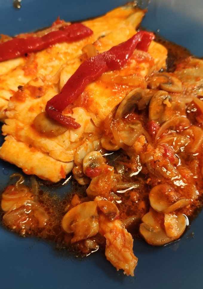 Una foto de Bacalao con cebolla, champis y salsa de tomate y pimientos de piquillo