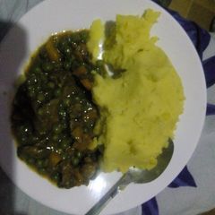 A picture of Mashed potatoes with beef and peas stew.