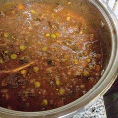 A picture of Beef stew with graden peas.