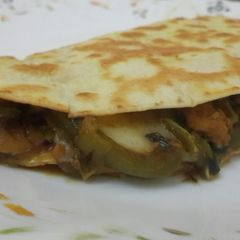 A picture of Cheese chicken and veggies tortilla wrap.