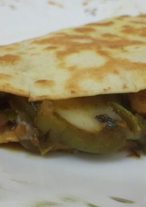 A picture of Cheese chicken and veggies tortilla wrap.