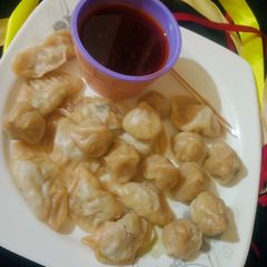 A picture of Mini chicken momos with dip sauce.
