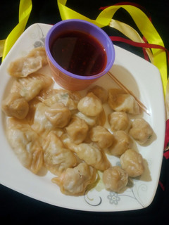 A picture of Mini chicken momos with dip sauce.