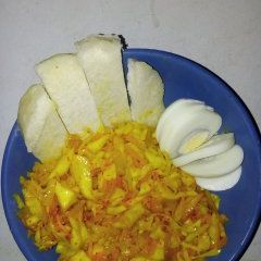 A picture of Cabbage and carrot stir fry with boiled egg.