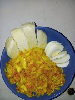 A picture of Cabbage and carrot stir fry with boiled egg.