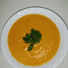 A picture of Pumpkin soup garnished with coriander.
