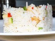 Una foto de arroz frito con cebolla, morrón