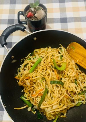 A picture of Veg Hakka noodles with spring onions.