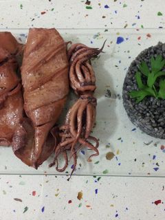 Una foto de Calamares en aceite con arroz negro