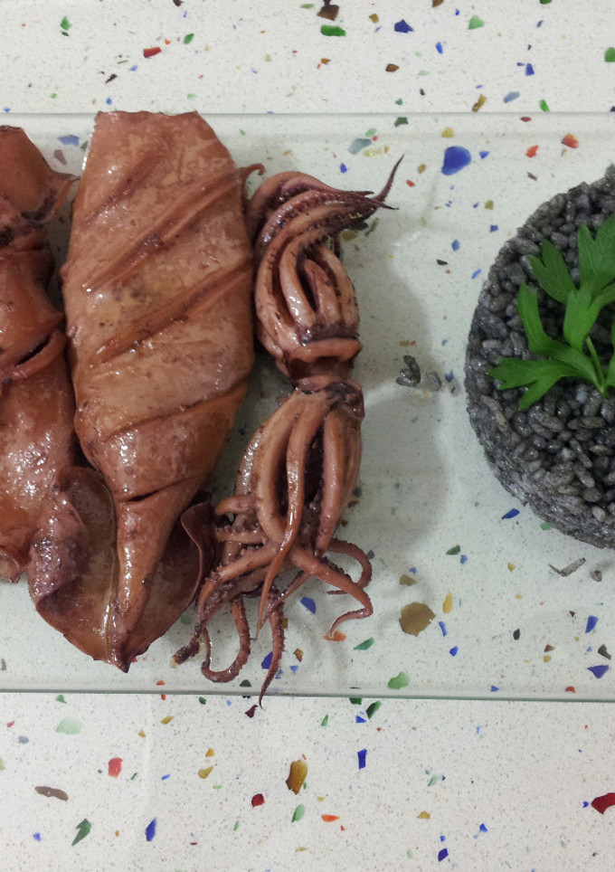 Una foto de Calamares en aceite con arroz negro