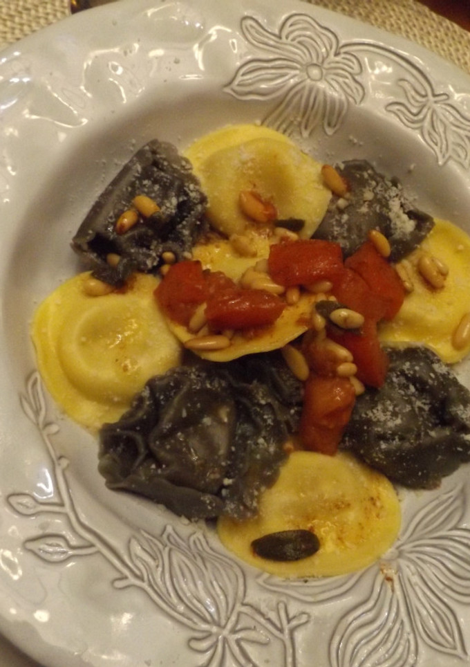 Una foto de Pasta rellena con cubitos de tomate, piñones y salvia a la mantequilla negra