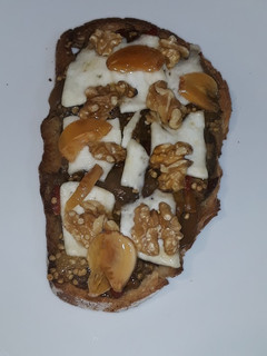 Una foto de Tostada de sanfaina con queso, nueces y miel de ajo