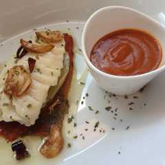 Una foto de Bacalao con salsa bizkaina y patatas con aroma de pimiento rojo asado