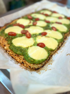 Una foto de Pizza de coliflor con pesto de espinacas estilo caprese